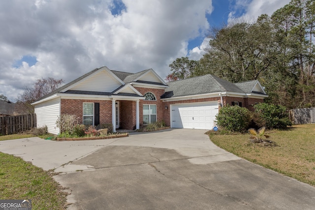 view of front of property featuring driveway, a garage, fence, a front lawn, and brick siding