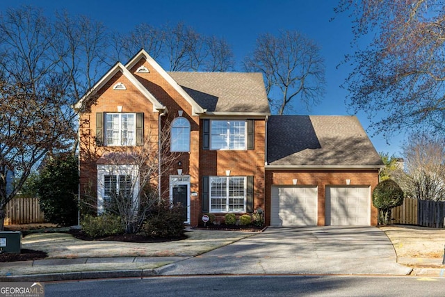 colonial home with driveway, brick siding, and fence