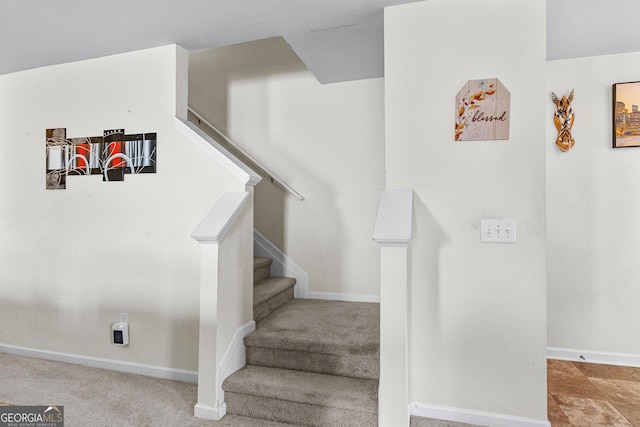 stairs with baseboards and carpet floors