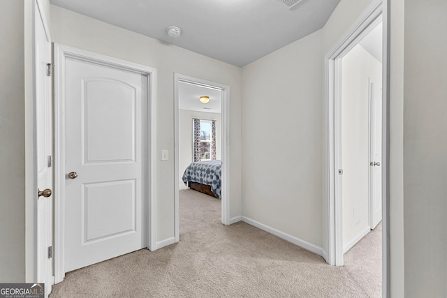 corridor with light carpet and baseboards