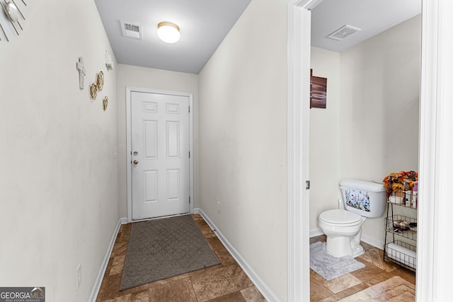 entryway featuring visible vents, stone finish floor, and baseboards