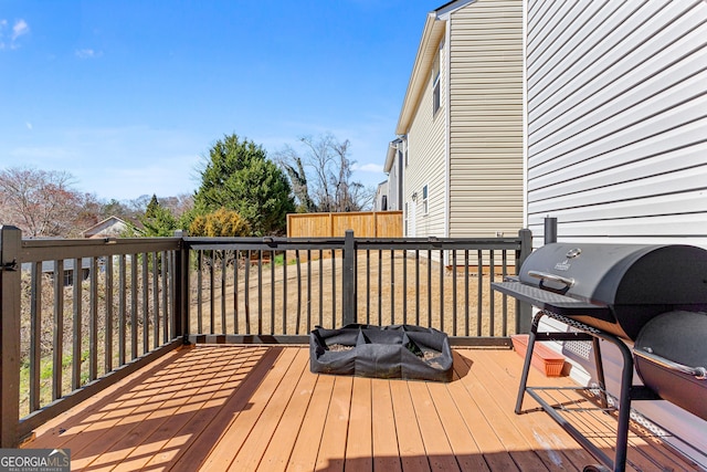 wooden deck with area for grilling and an outdoor fire pit