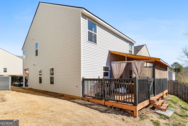 back of property featuring central air condition unit, fence, and a wooden deck