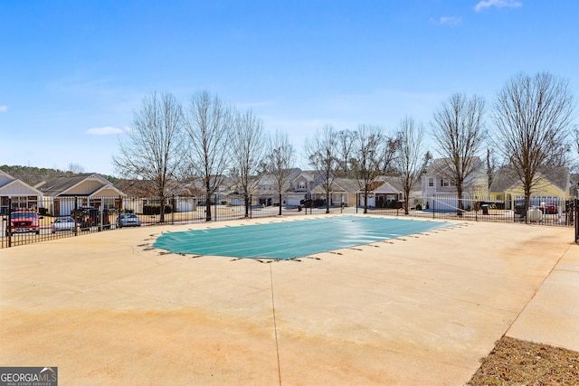 view of pool with a patio area, a residential view, and fence