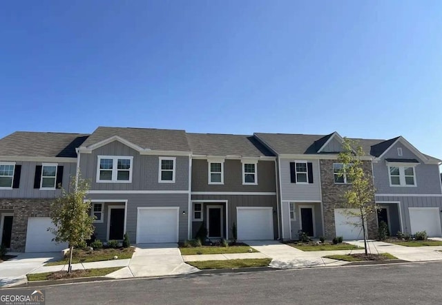 view of property featuring driveway, an attached garage, and board and batten siding