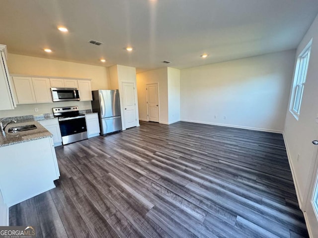 kitchen with dark wood finished floors, visible vents, appliances with stainless steel finishes, white cabinetry, and a sink