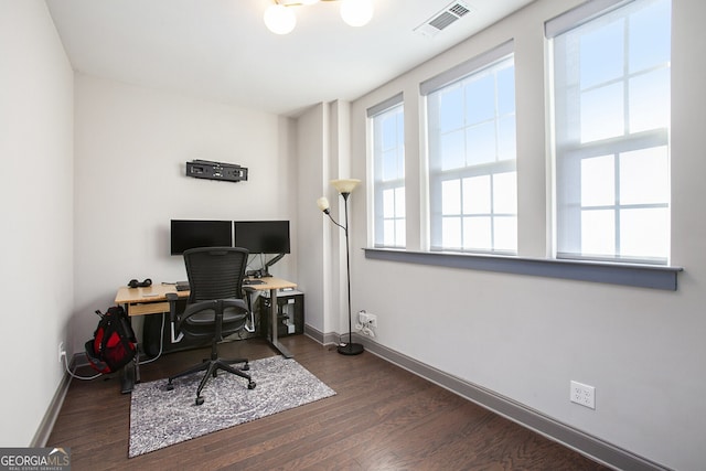 office area featuring a healthy amount of sunlight, baseboards, visible vents, and wood finished floors