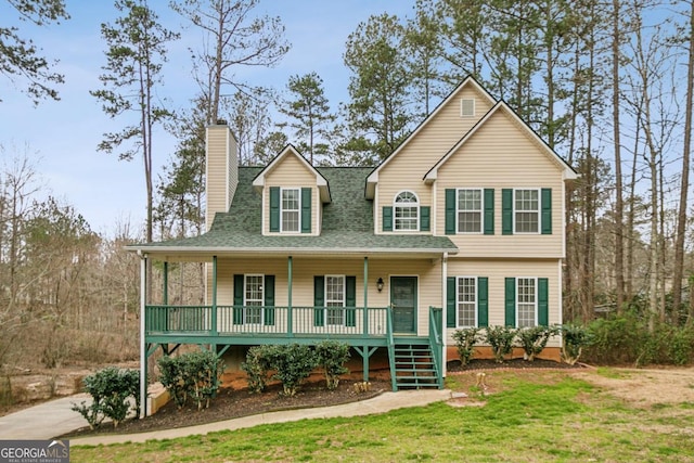 view of front of home featuring a porch, a chimney, a shingled roof, and a front lawn