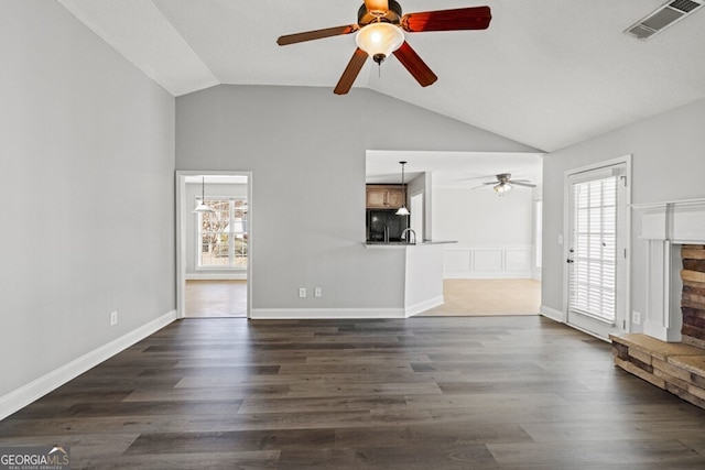 1409 Nantucket Dr, Bethlehem, GA 30620 - unfurnished living room featuring a ceiling fan, lofted ceiling, dark wood finished floors, and a stone fireplace