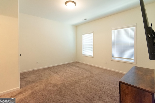 carpeted empty room with visible vents and baseboards