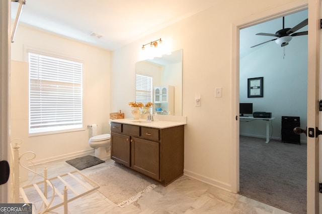 bathroom featuring ceiling fan, toilet, visible vents, vanity, and baseboards