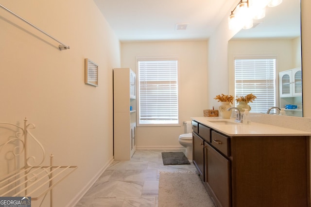 bathroom featuring visible vents, baseboards, vanity, and toilet