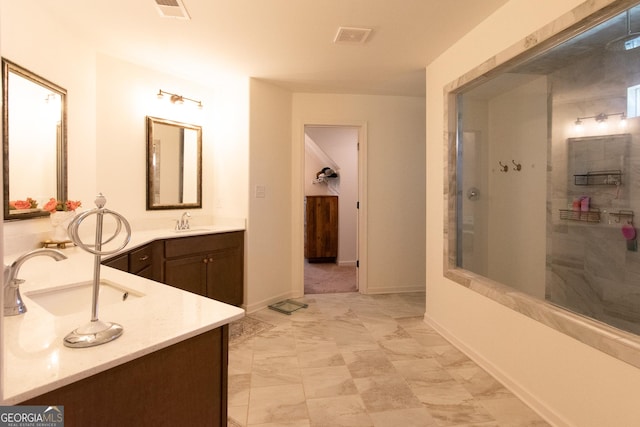 bathroom featuring visible vents, vanity, baseboards, and a walk in shower