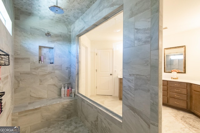 bathroom featuring tiled shower and vanity