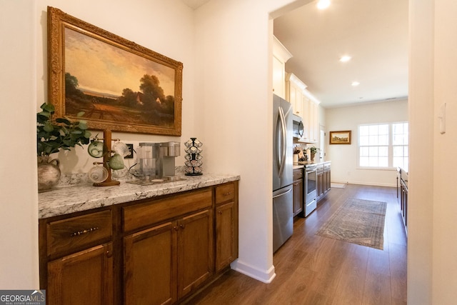 kitchen featuring recessed lighting, stainless steel appliances, baseboards, light stone countertops, and dark wood-style floors