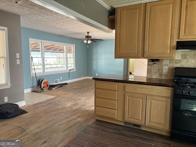 kitchen with visible vents, backsplash, black range with gas stovetop, dark wood-type flooring, and under cabinet range hood