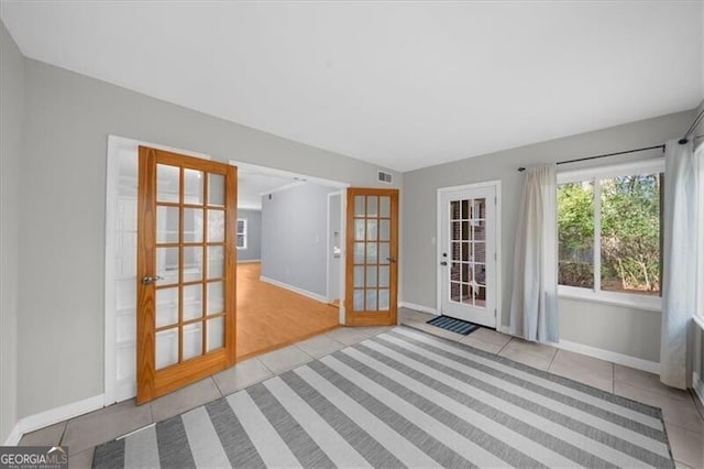 interior space featuring french doors, visible vents, baseboards, and tile patterned floors