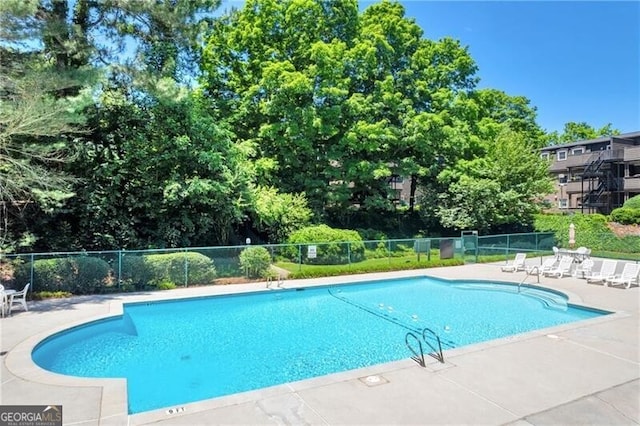 pool featuring a patio area and fence