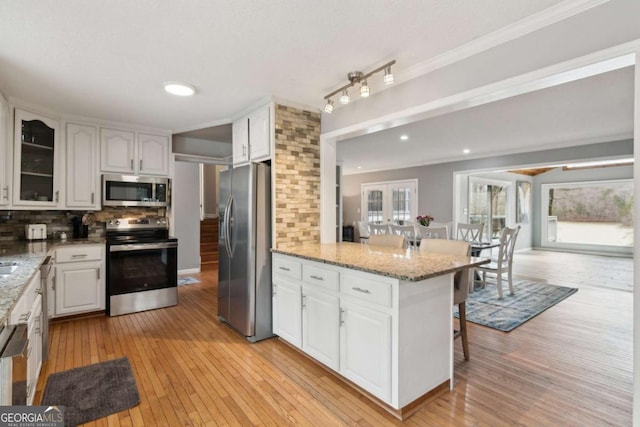 kitchen featuring light wood finished floors, white cabinetry, and stainless steel appliances