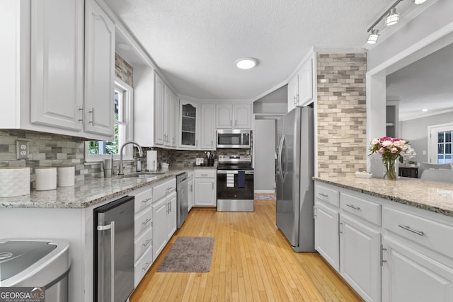 3928 Lake Ct, Gainesville, GA 30501 - kitchen featuring a sink, stainless steel appliances, white cabinetry, decorative backsplash, and a wealth of natural light