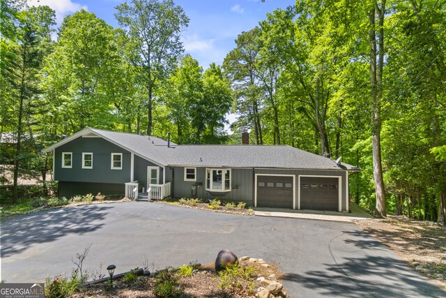 3928 Lake Ct, Gainesville, GA 30501 - split level home with driveway, a chimney, a shingled roof, and a garage