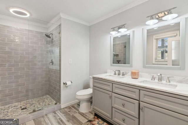 bathroom with tiled shower, a sink, and crown molding