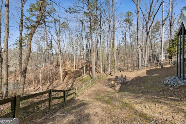 view of yard with fence and a view of trees