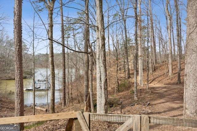 view of yard with a forest view and a water view