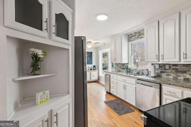 kitchen featuring appliances with stainless steel finishes, a sink, and white cabinets