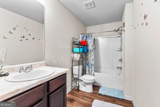 full bath with visible vents, shower / bath combo with shower curtain, toilet, wood finished floors, and vanity