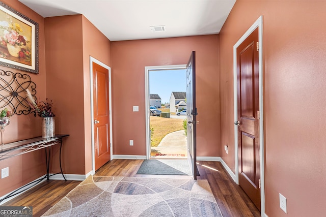 foyer entrance with dark wood-style floors and baseboards