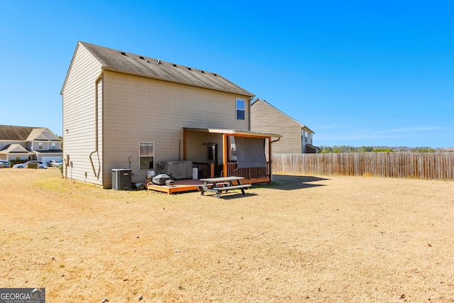 rear view of house with cooling unit, fence, and a wooden deck