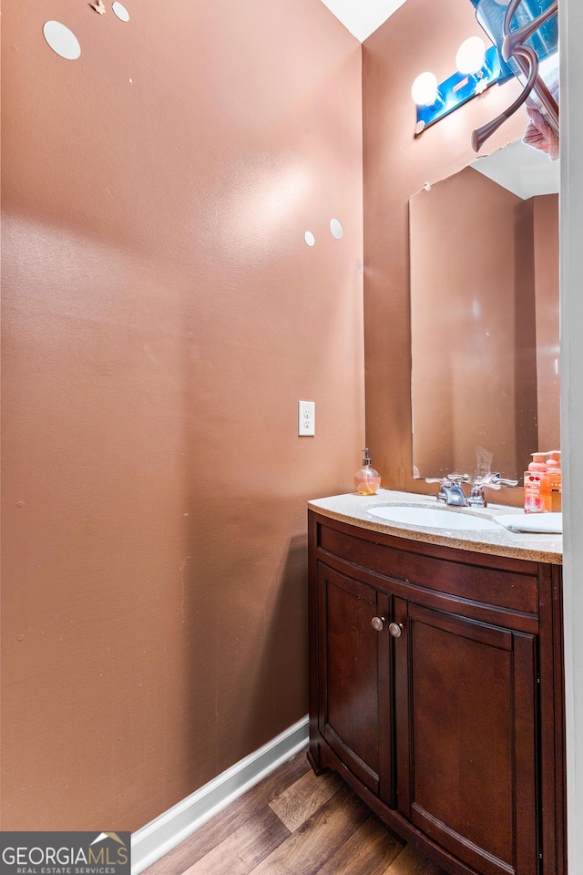 bathroom featuring vanity, wood finished floors, and baseboards