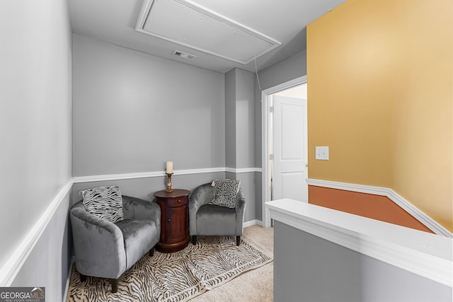 living area with visible vents, carpet, and attic access