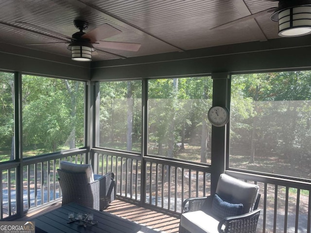 unfurnished sunroom featuring a ceiling fan