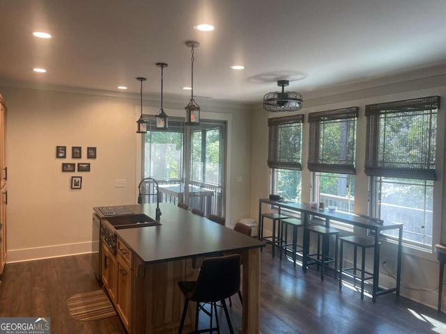 kitchen featuring baseboards, dark wood finished floors, a center island, a sink, and recessed lighting