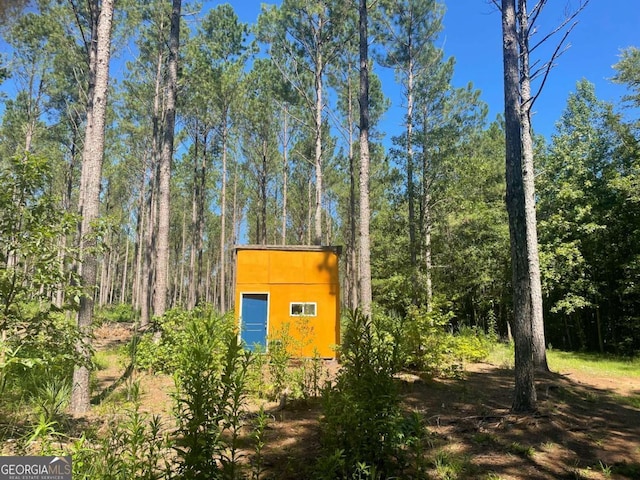 view of outdoor structure with a wooded view