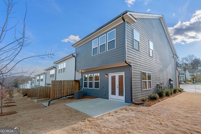 back of property featuring french doors, a patio area, central AC, and fence