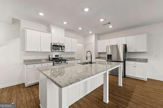 kitchen with a sink, stainless steel appliances, visible vents, and white cabinets