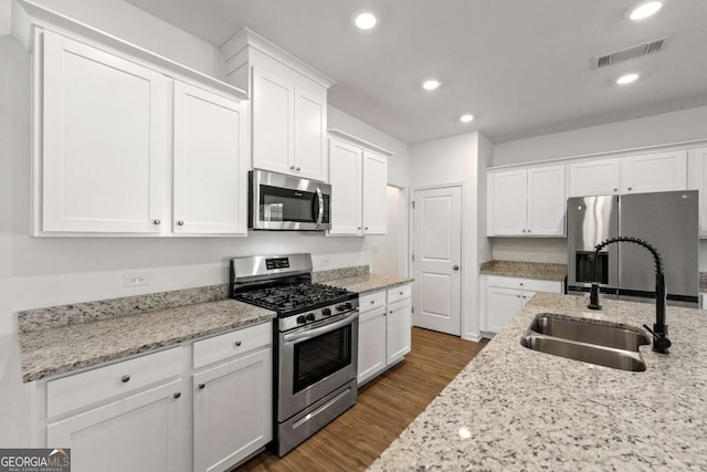 kitchen featuring visible vents, a sink, dark wood-style floors, white cabinetry, and appliances with stainless steel finishes