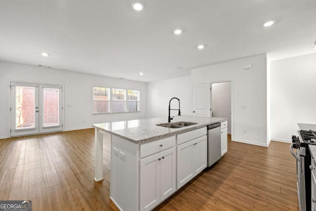 kitchen featuring white cabinets, appliances with stainless steel finishes, wood finished floors, and a sink