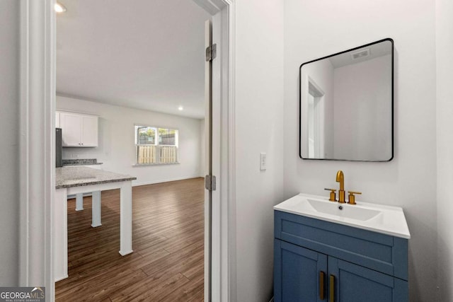 bathroom with vanity, baseboards, and wood finished floors