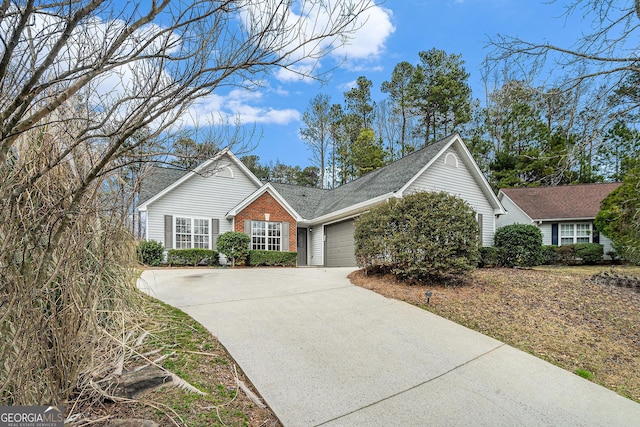 view of front of home with driveway, brick siding, and an attached garage