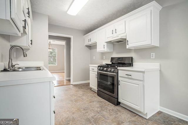 kitchen with stainless steel gas range, white cabinetry, a sink, and under cabinet range hood