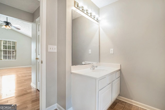 bathroom with lofted ceiling, a ceiling fan, vanity, a textured ceiling, and wood finished floors