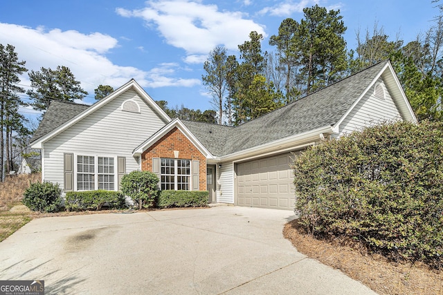 view of front of house featuring a shingled roof, concrete driveway, brick siding, and an attached garage