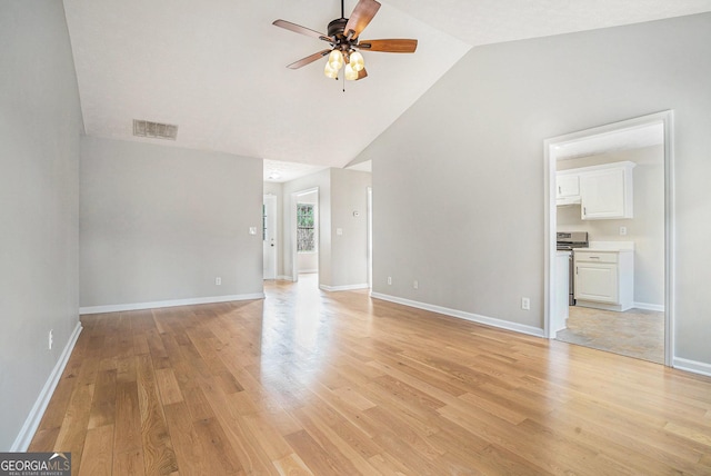 unfurnished room featuring lofted ceiling, visible vents, light wood-style flooring, a ceiling fan, and baseboards