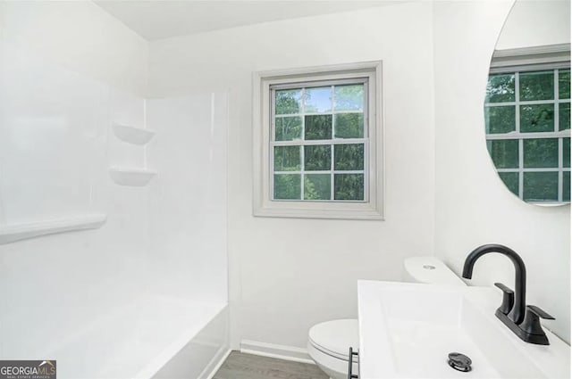 full bath featuring toilet, baseboards, a sink, and wood finished floors