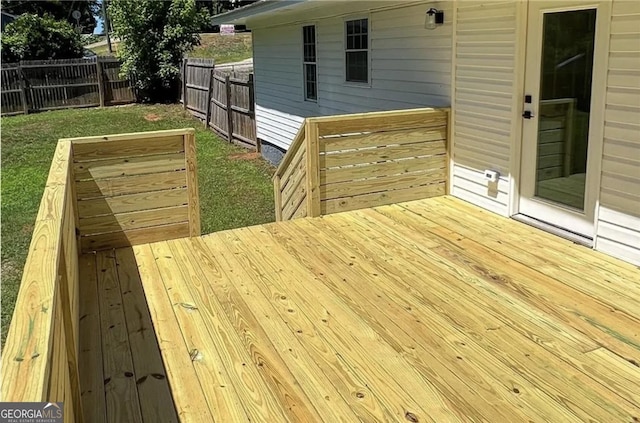 wooden terrace with a yard and fence