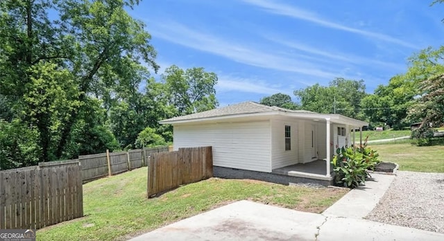 view of side of home featuring a yard and fence